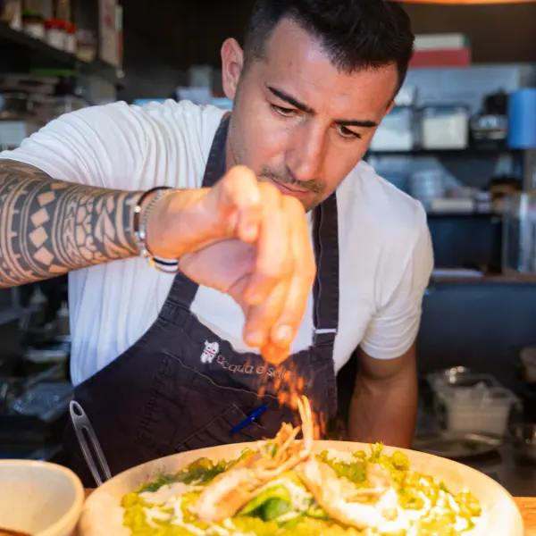 A chef finishing a dish in the kitchen photographed for restaurant photography in Perth.