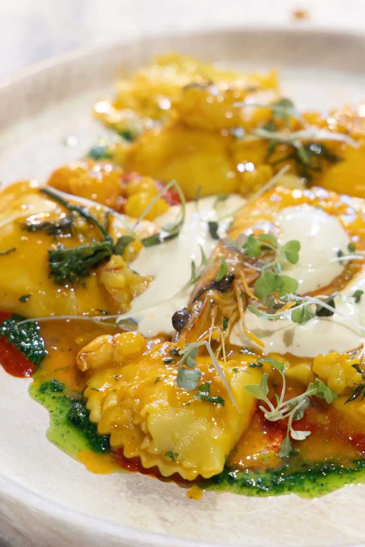 Filled pasta with cream sauce, herbs, and microgreens plated at Acqua e Sale