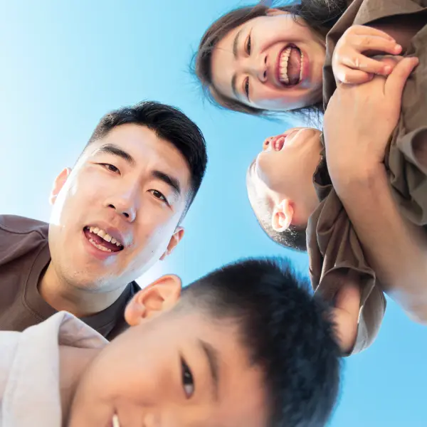 Family of four sharing a playful low-angle portrait outdoors in Perth.