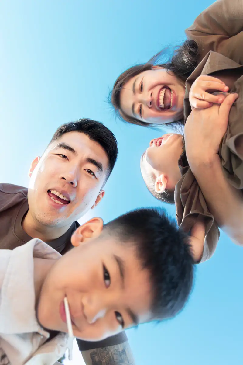 Family of four sharing a playful low-angle portrait outdoors in Perth.
