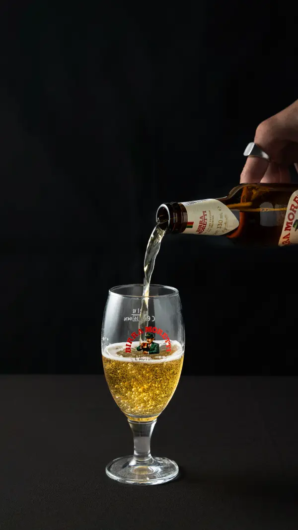 Craft beer being poured into a branded glass, beverage pour photography by Amplify Creative Lab in Perth.