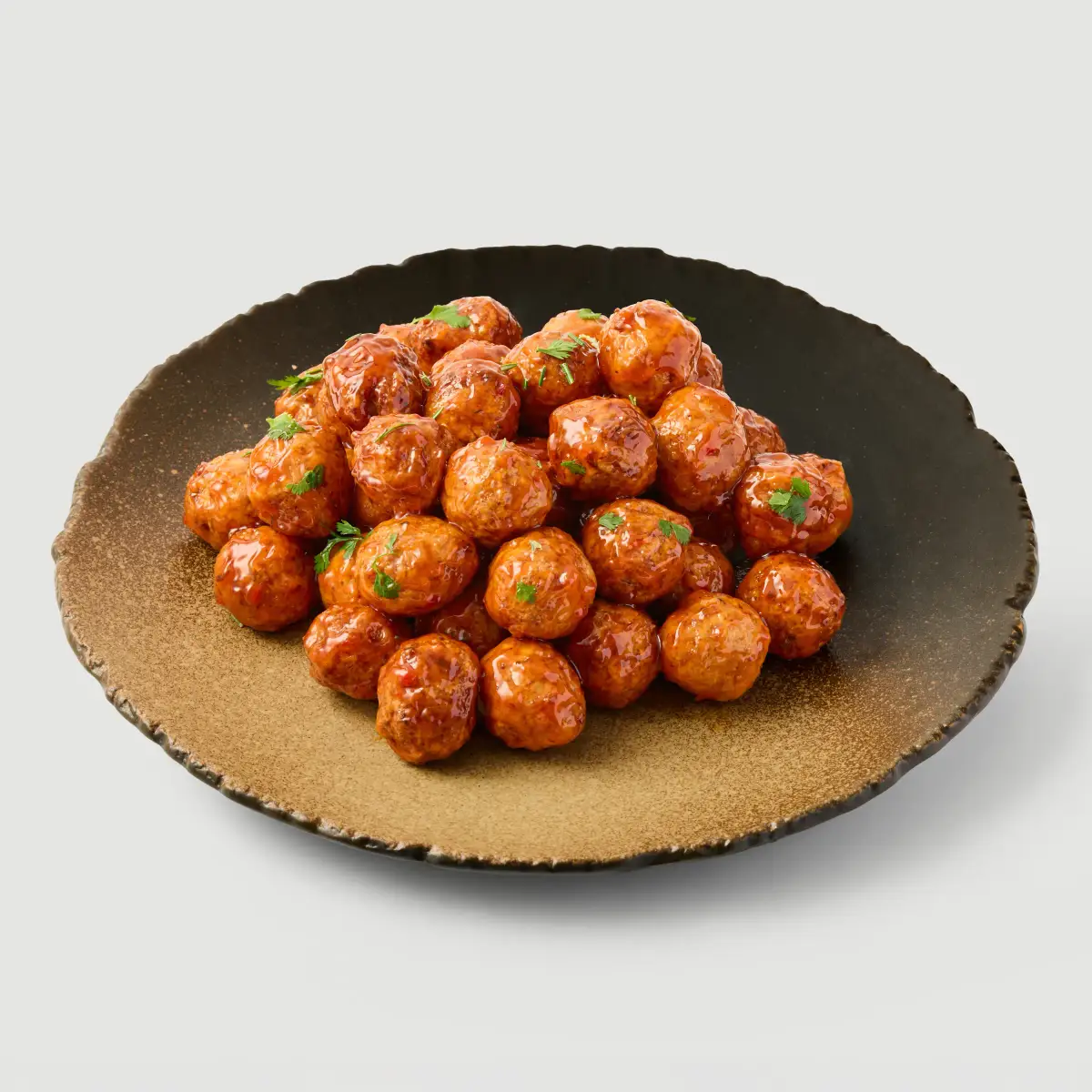 Glazed bite-sized prepared-food product served on a dark ceramic plate against a white background