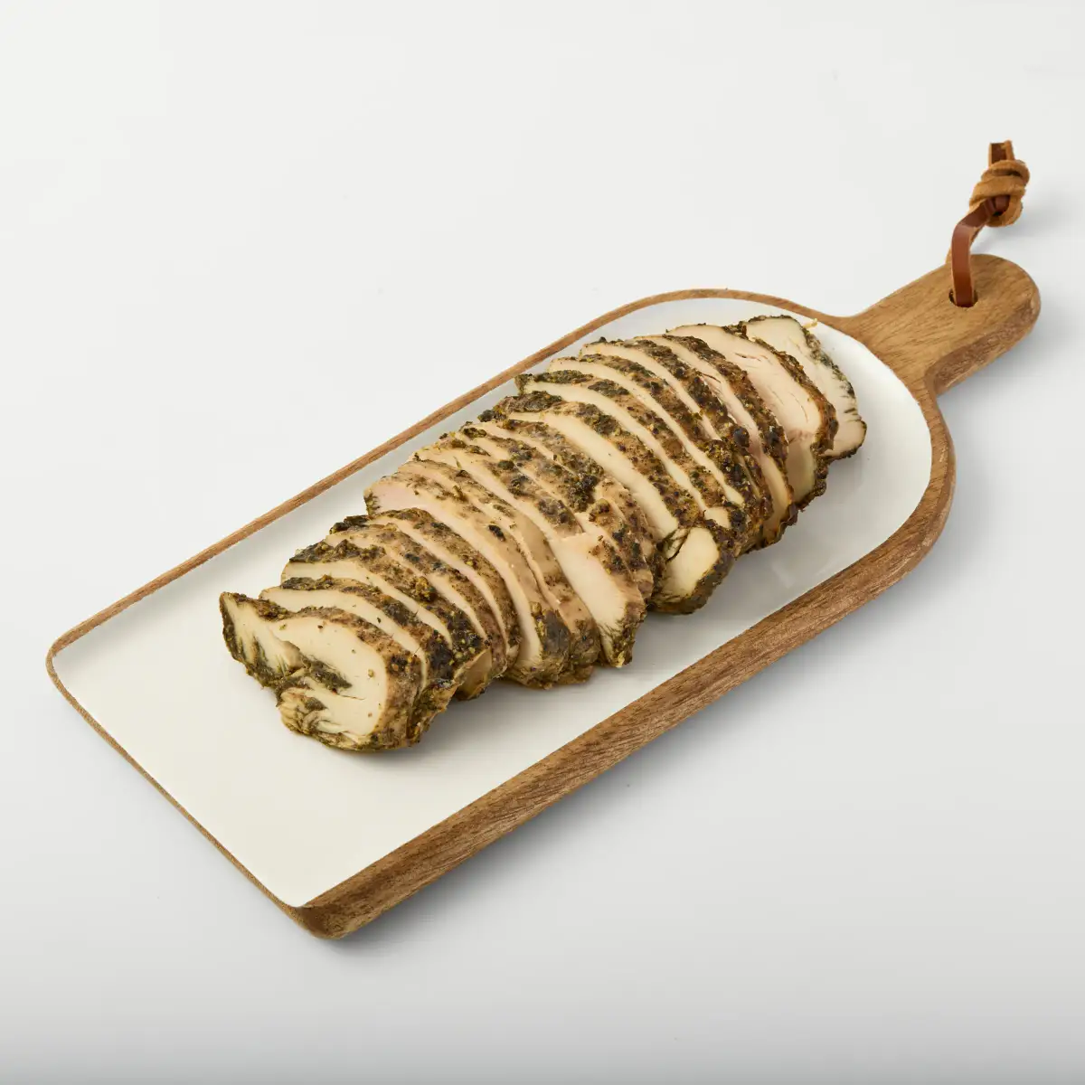 Seasoned sliced prepared-food product arranged on a timber-handled serving board against a white background
