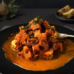 Rich pork ragu served over grilled polenta, styled with moody lighting for premium restaurant food photography in Perth.