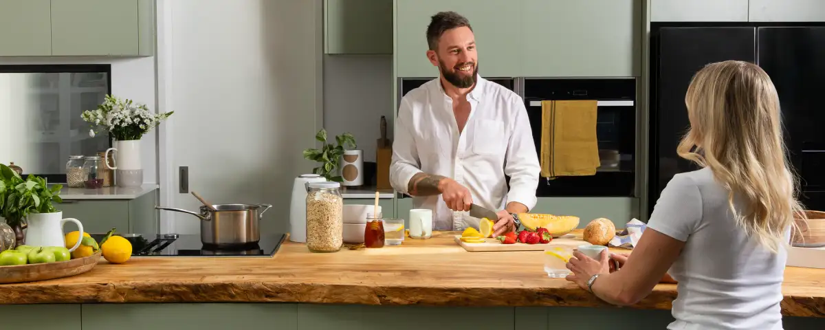 Commercial lifestyle shot of a couple preparing food in a modern kitchen, ideal for brand web design.
