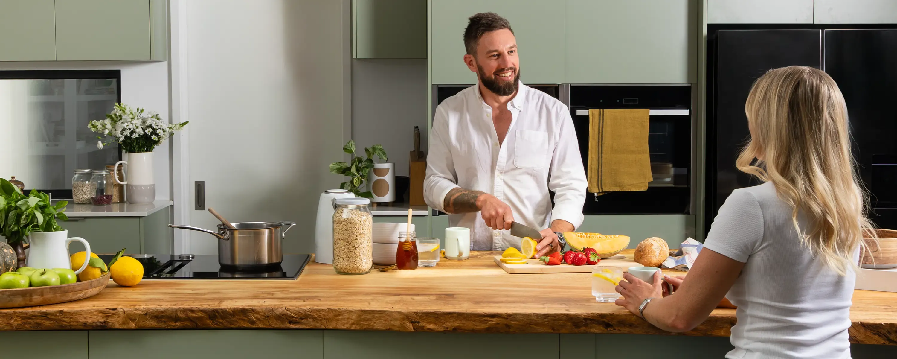 Commercial lifestyle shot of a couple preparing food in a modern kitchen, ideal for brand web design.