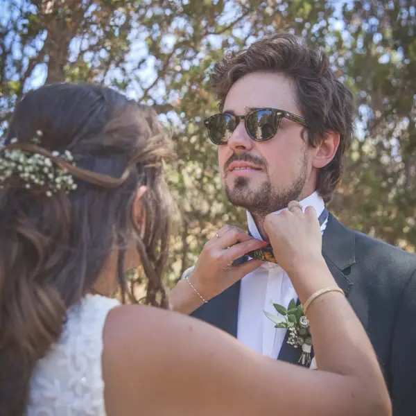 Bride adjusting the groom's bow tie before an intimate Perth wedding.