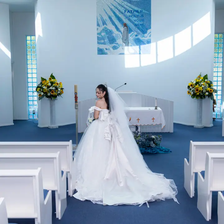 Full-length bridal portrait at the altar inside the church with the veil and dress train on display.