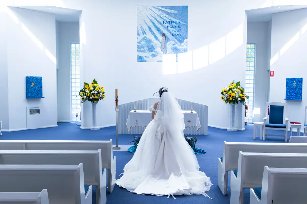 Bride standing at the altar during the wedding ceremony inside Pater Noster Catholic Church