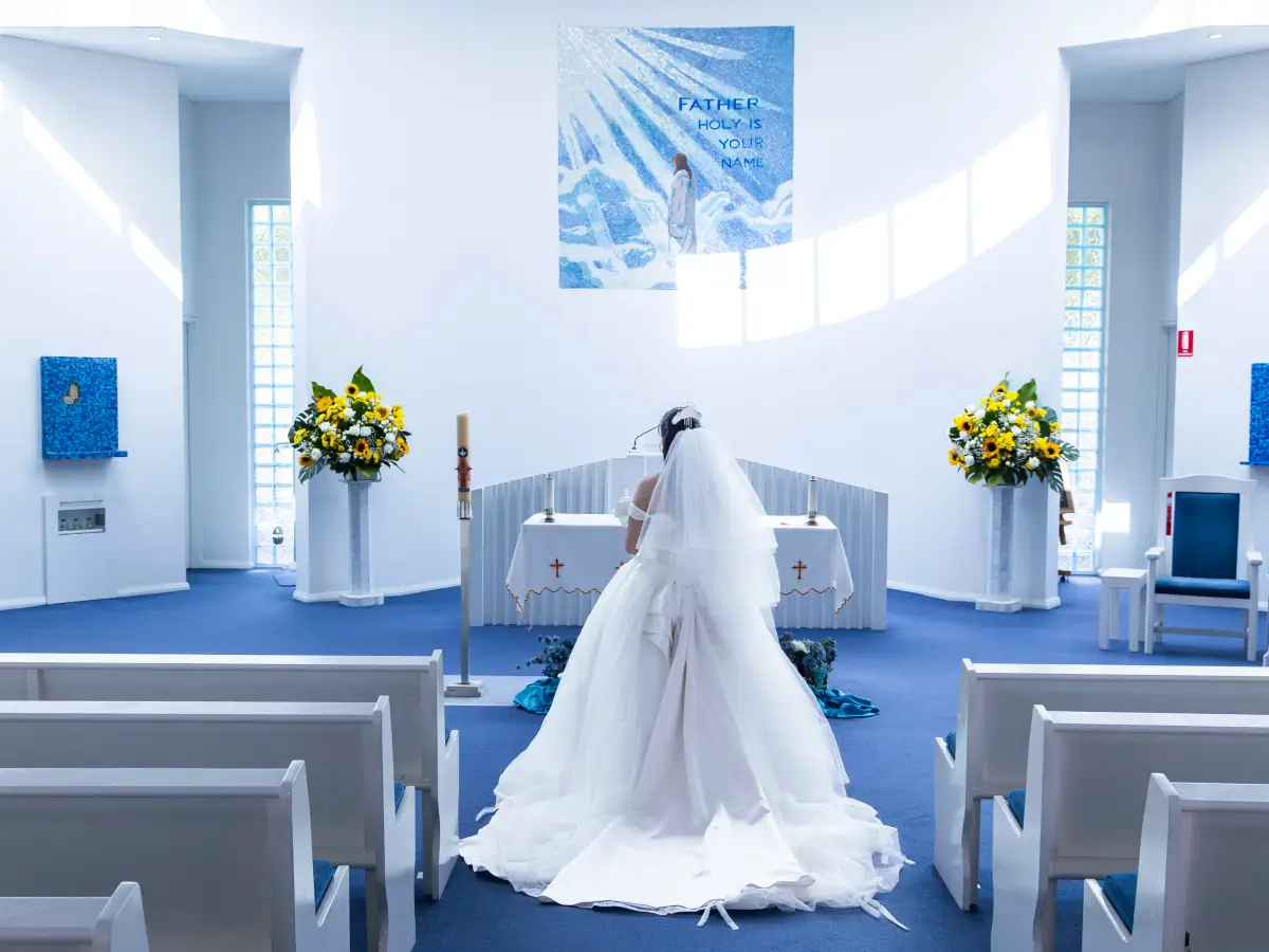 Bride standing at the altar during the wedding ceremony inside Pater Noster Catholic Church