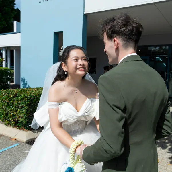Bride smiling at the groom outside the church after their ceremony.
