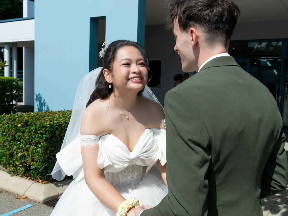 Bride smiling at the groom outside Pater Noster Catholic Church after the ceremony