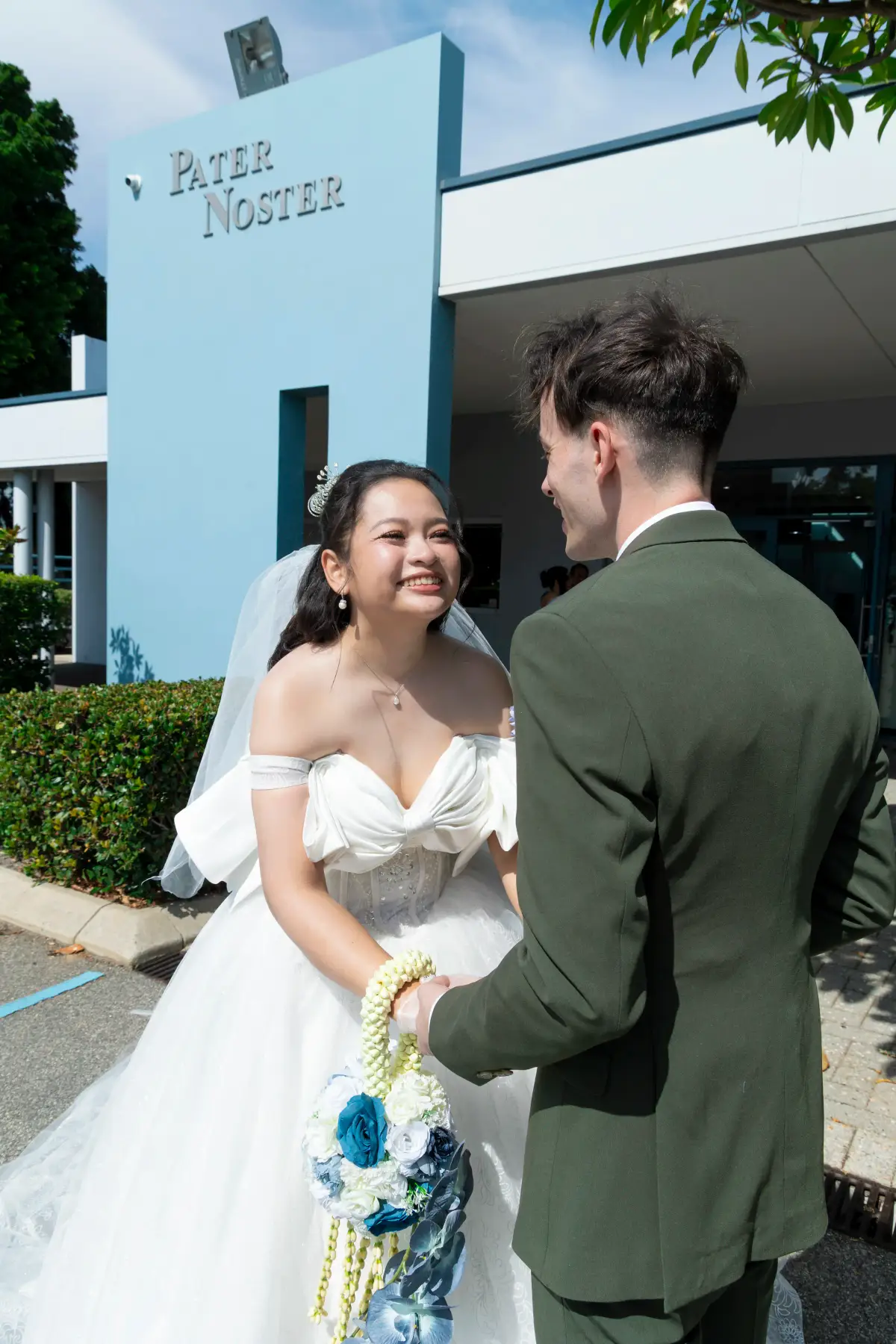 Bride smiling at the groom outside Pater Noster Catholic Church after the ceremony