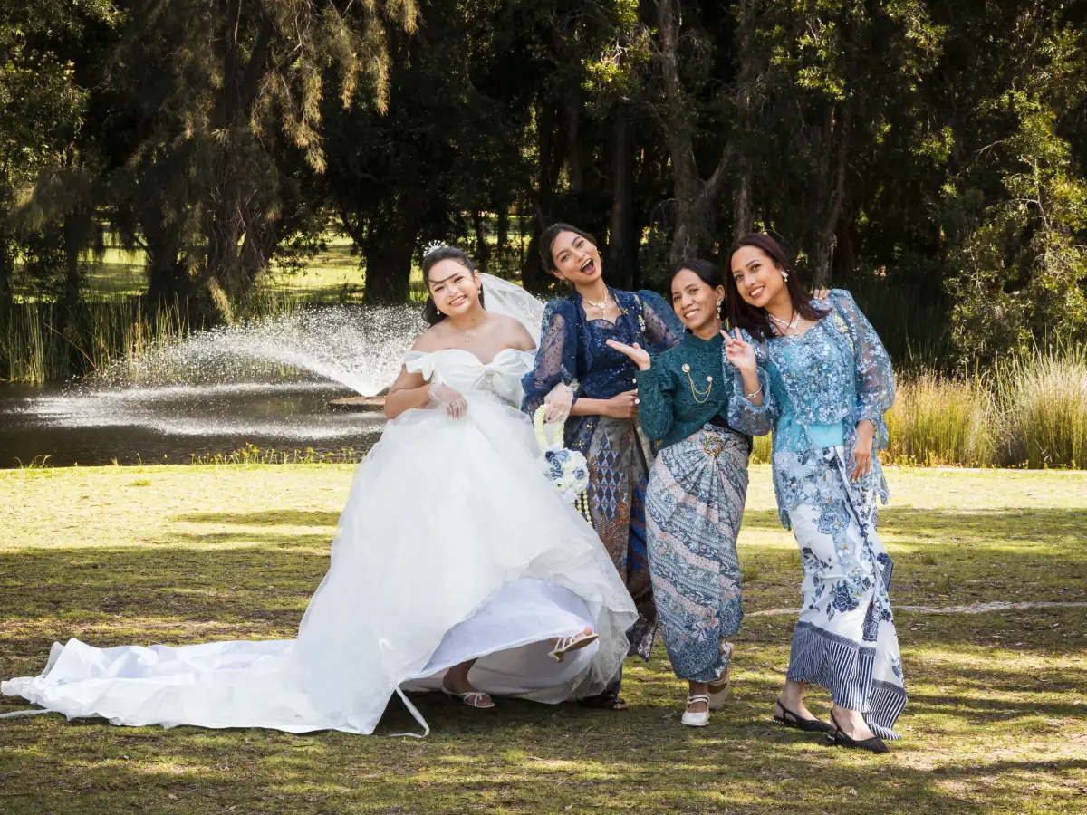 Bride with bridesmaids posing beside a fountain during post-ceremony portraits