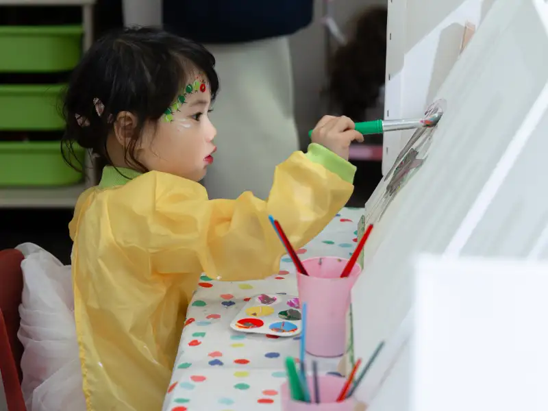Child painting during an activity at a Perth birthday party.