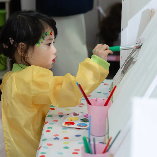Child taking part in a painting activity at a Perth birthday party.