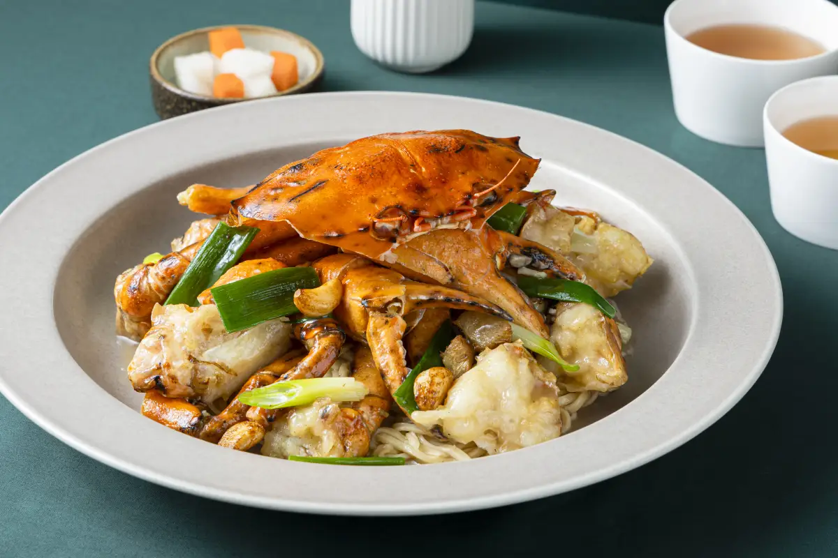 Crab and noodle dish plated with spring onion at Como Garden Restaurant