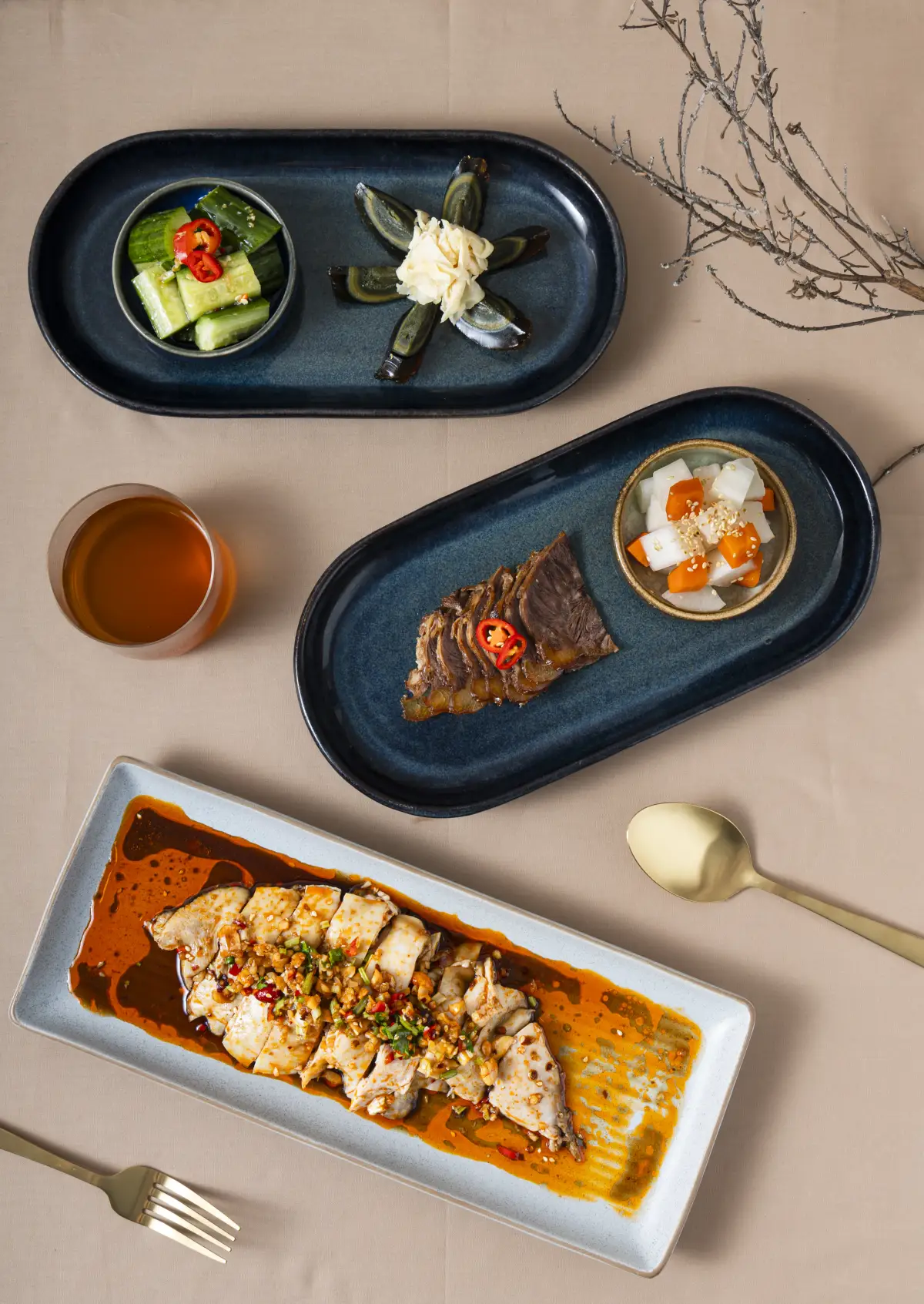 Top-down composition of multiple seasonal dishes styled on neutral tones at Como Garden