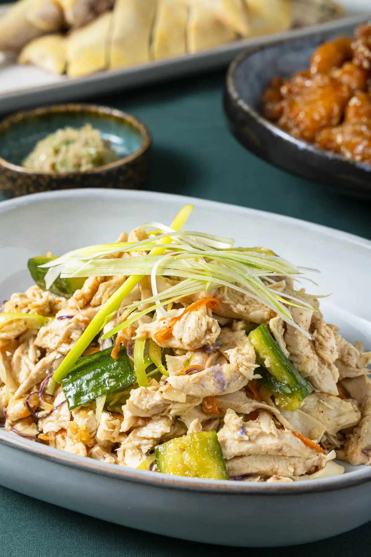 Shredded chicken dish with scallion garnish plated for Como Garden's seasonal menu