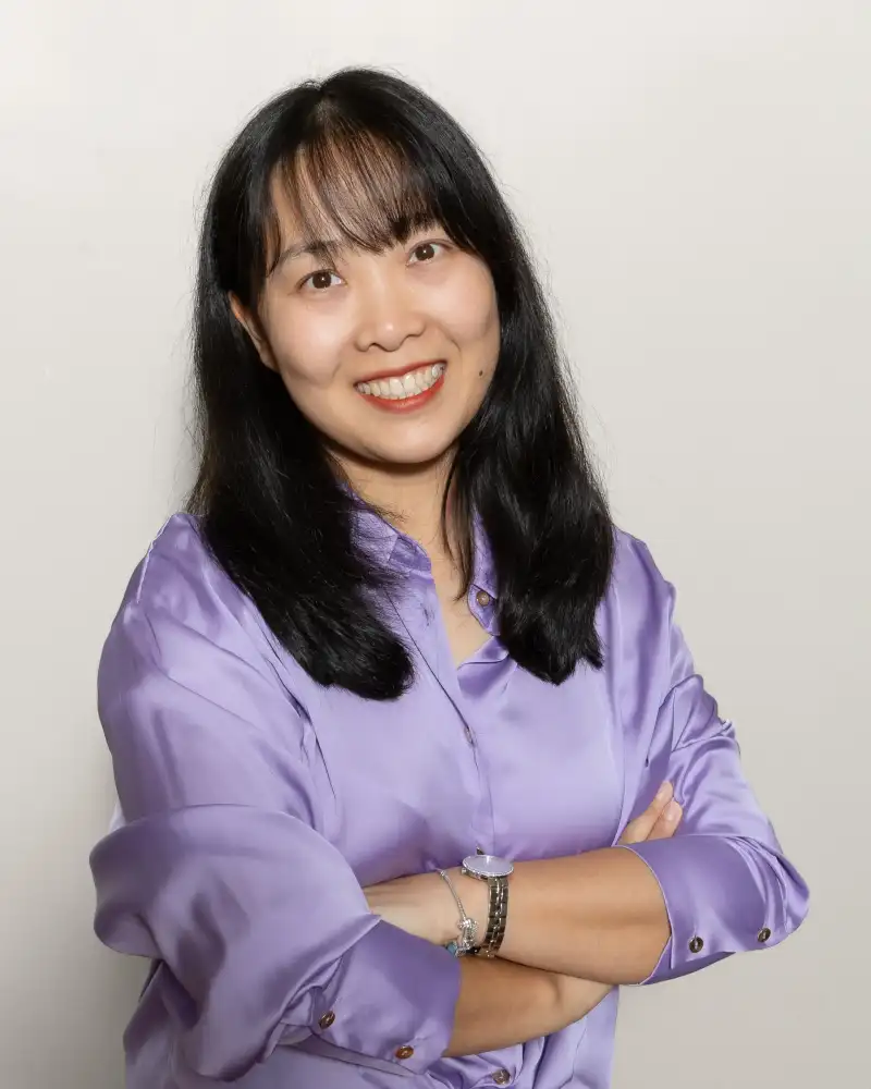 Professional corporate headshot of a woman in a purple shirt, photographed in a Perth studio for business branding