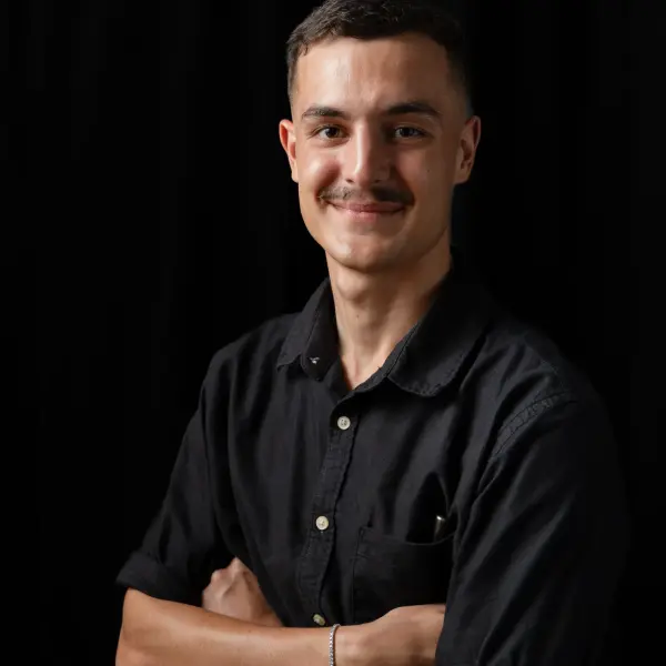 Creative professional photographed against a dark studio background.