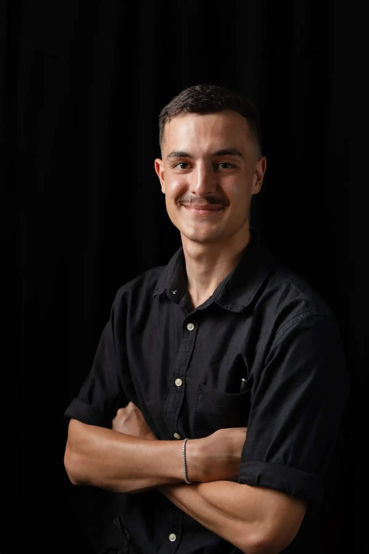 Creative professional photographed against a dark studio background.