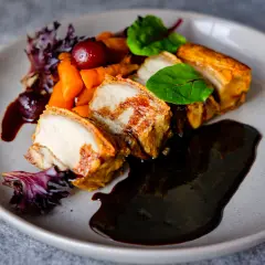 Plated crispy pork belly with rich jus, fine dining food photography for Perth hospitality brand identity and website.