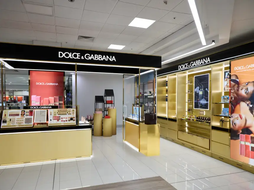 Wide view of the completed Dolce&Gabbana Beauty concession at Myer Perth showing the gold fitout, black signage, lip and face display counter and backlit fragrance wall