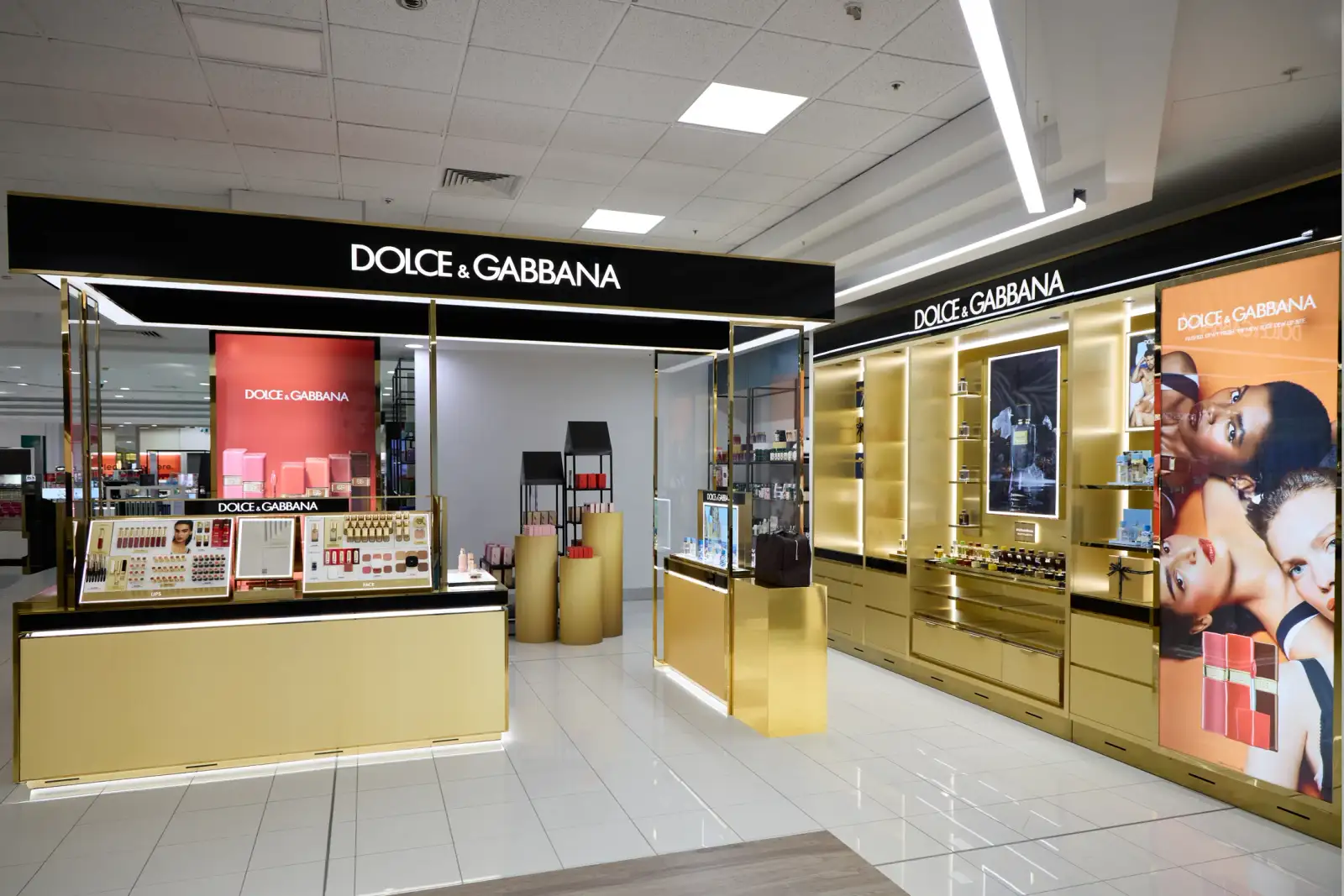 Wide view of the completed Dolce&Gabbana Beauty concession at Myer Perth showing the gold fitout, black signage, lip and face display counter and backlit fragrance wall