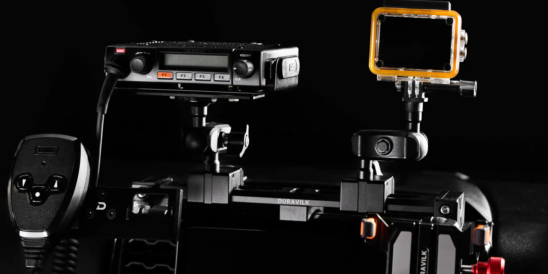 Duravilk dashboard mounting rail holding a radio and an action camera, with a branded device holder and red adjustment knob in the foreground