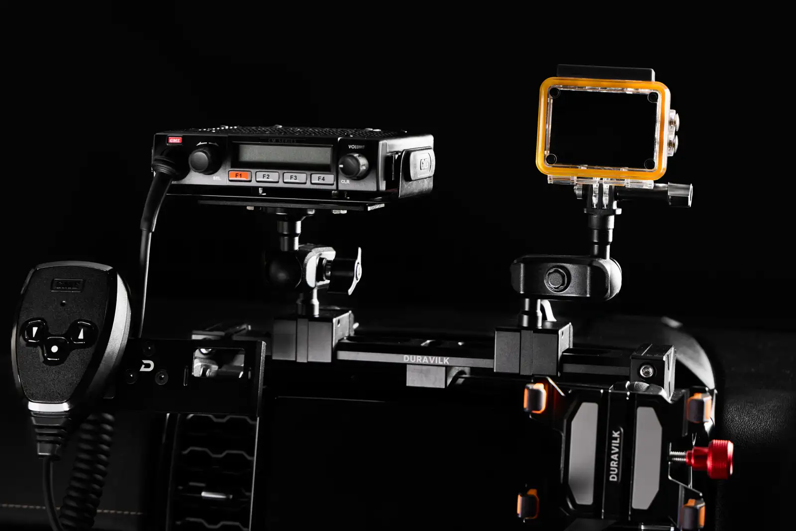 Duravilk dashboard mounting rail holding a radio and an action camera, with a branded device holder and red adjustment knob in the foreground