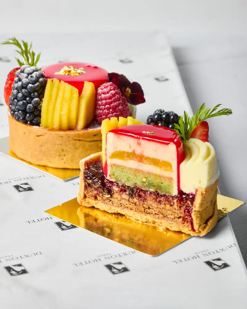 A berry tart and layered cake photographed for cafe photography in Perth.