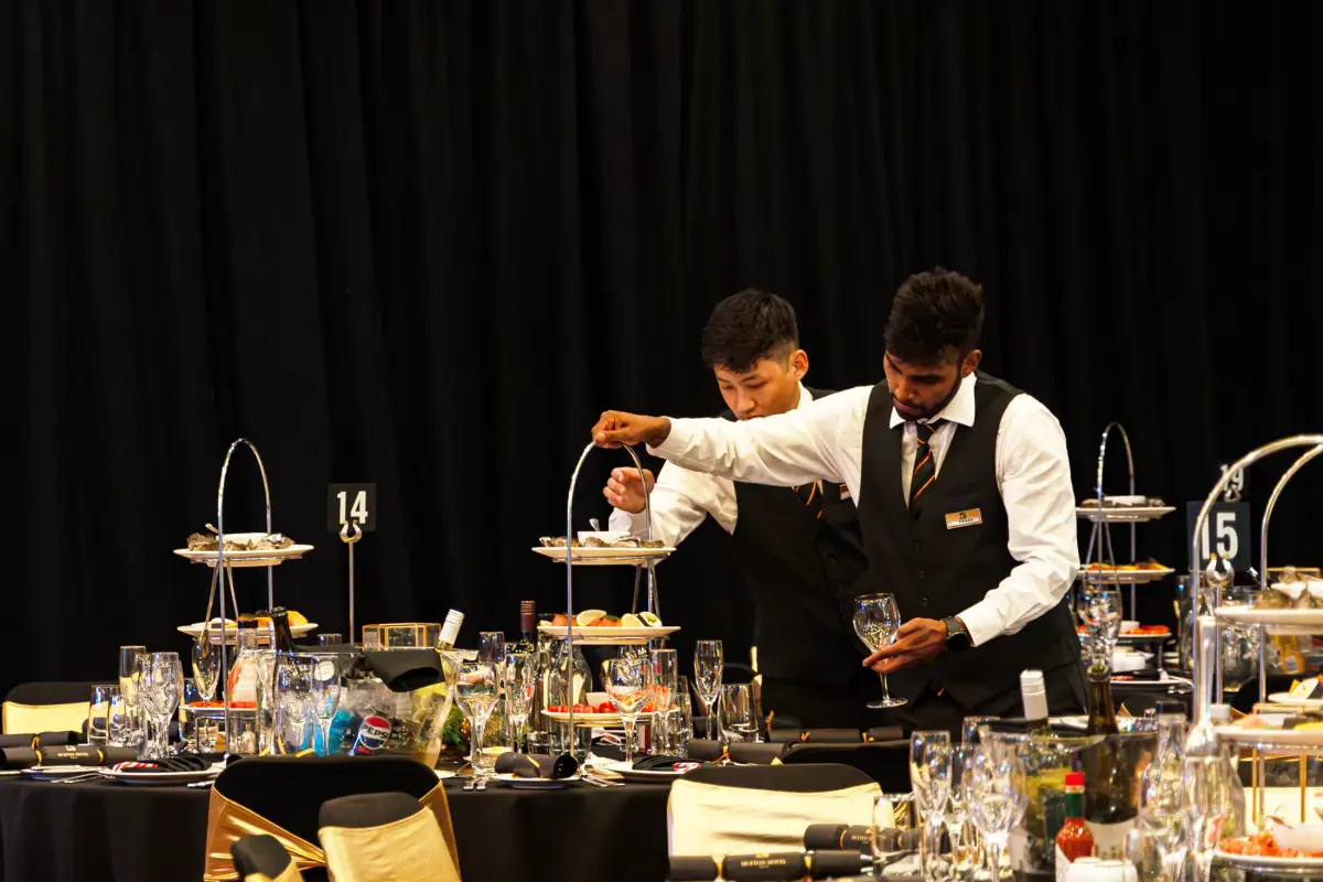 Duxton Hotel Perth staff preparing glassware and tiered table settings before ballroom guests arrive