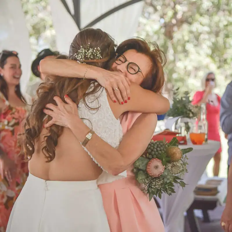 Wedding guests sharing an emotional hug at a private reception.