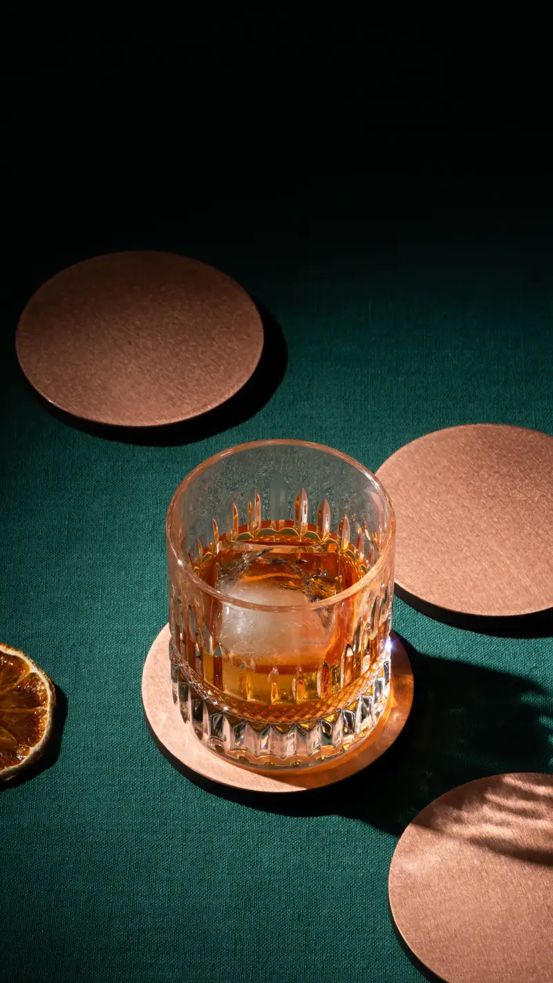 Stacked metal coasters photographed close up to show thickness and finish.