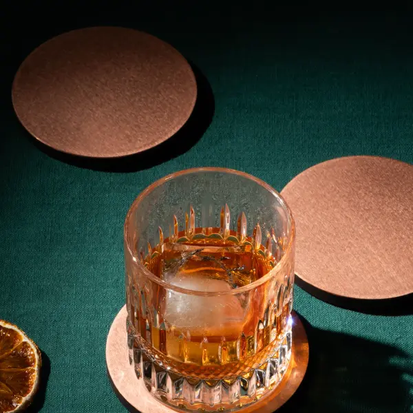 Stacked metal coasters photographed close up to show thickness and finish.