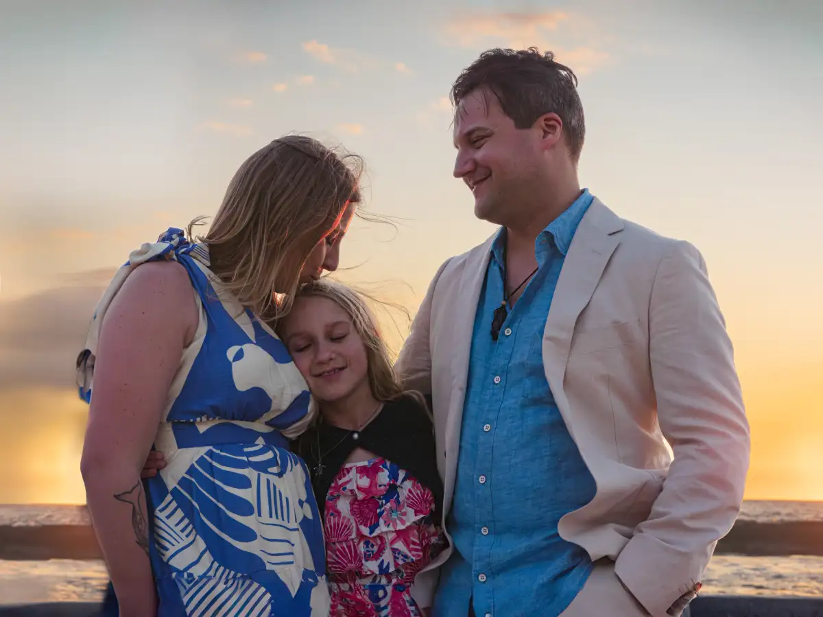 Family sharing an affectionate moment during a sunset portrait session.
