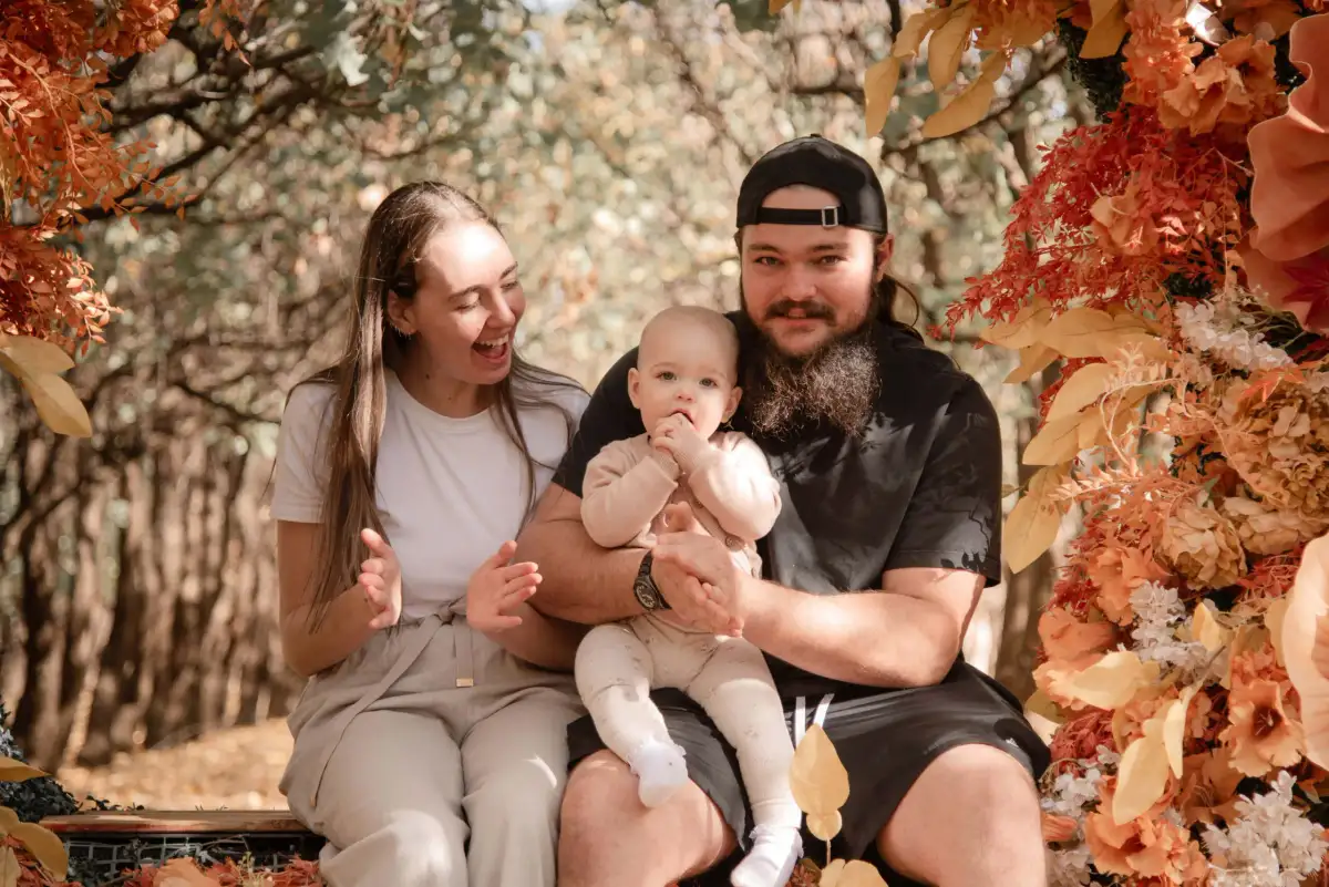 Family portrait beneath an autumn floral arch.