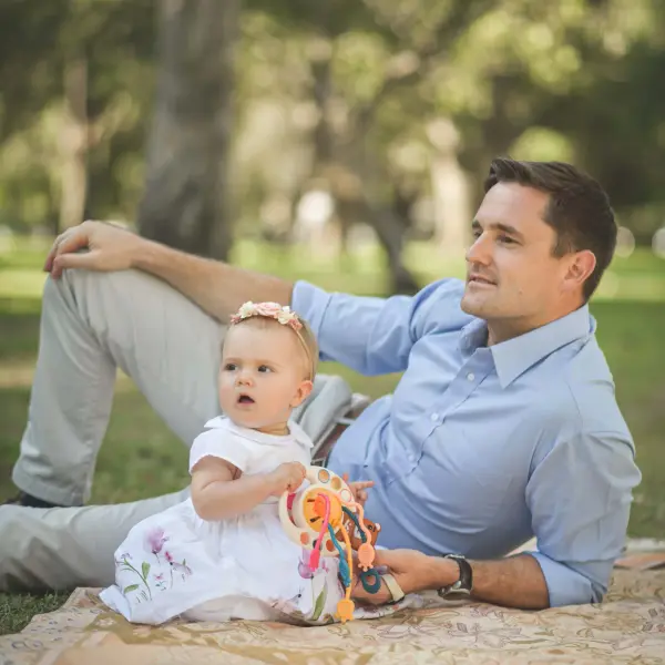 Father and daughter sharing a relaxed moment during an outdoor portrait session.