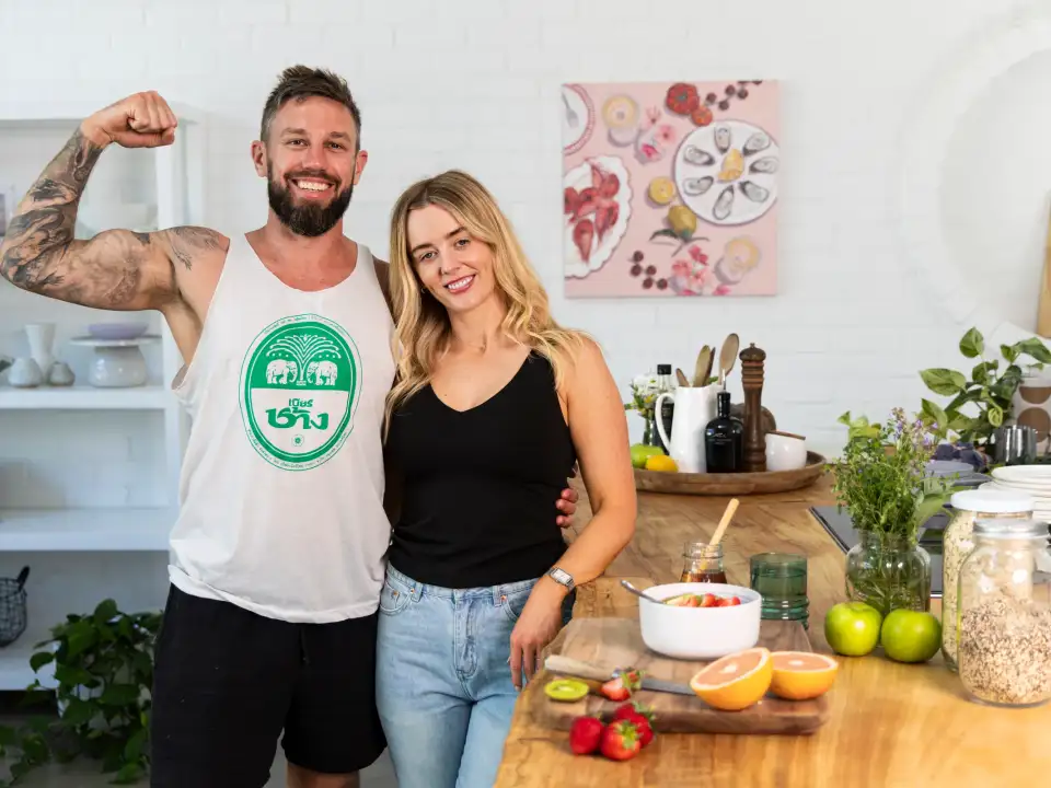 Two people standing in a bright kitchen beside fruit, oats, and a breakfast bowl for Fertility Fuelled brand photography