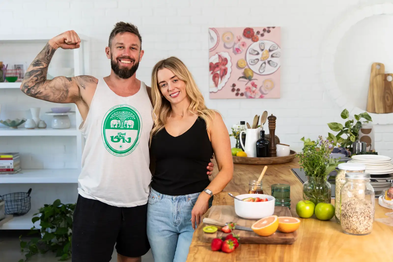 Two people standing in a bright kitchen beside fruit, oats, and a breakfast bowl for Fertility Fuelled brand photography