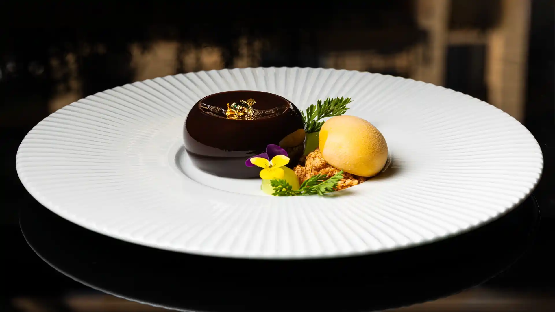 Elegant dark chocolate mousse dome with gold leaf, showcasing fine dining photography services in Perth, WA.