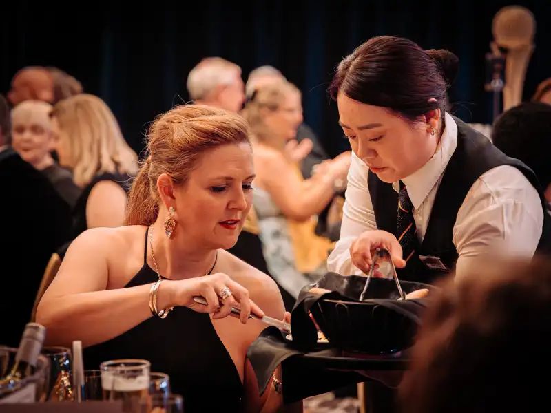 Formal gala dinner service at a Perth corporate event venue with elegant table settings and ambient lighting