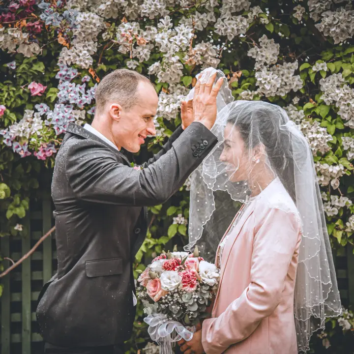 Groom lifting the bridal veil during a candid wedding portrait session in Perth.