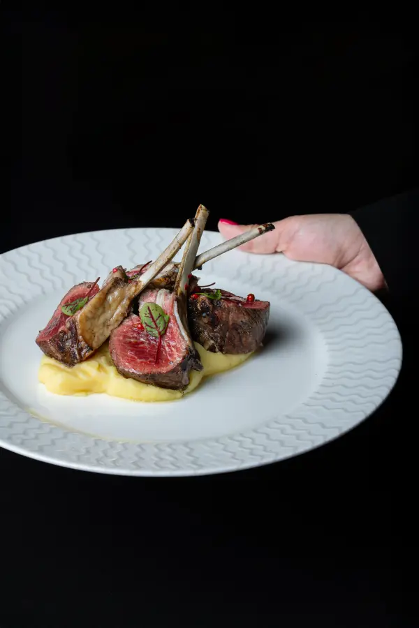 Herb-crusted lamb rack plated for a Perth fine dining restaurant, professional food photography.