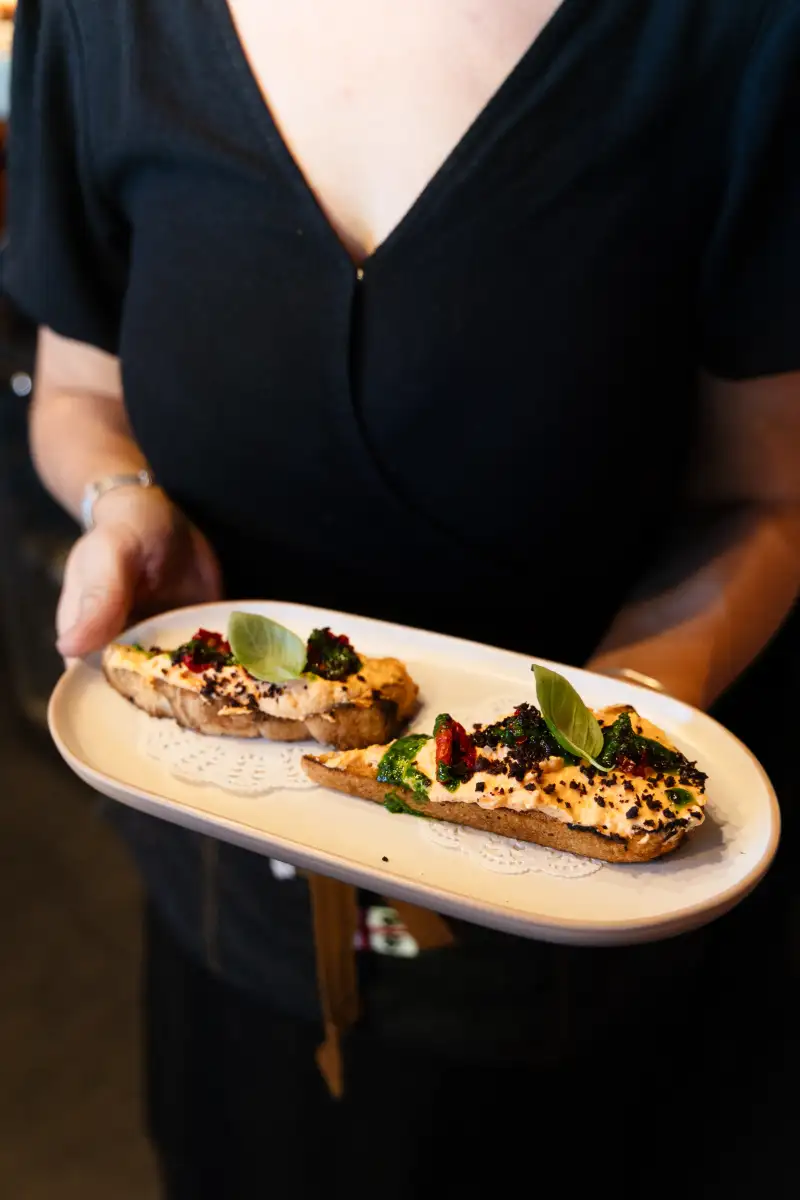 Staff presenting catered food during service photographed for catering photography in Perth.