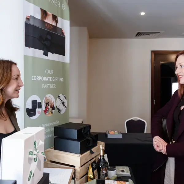 Exhibitor speaking with a visitor at a Perth business summit