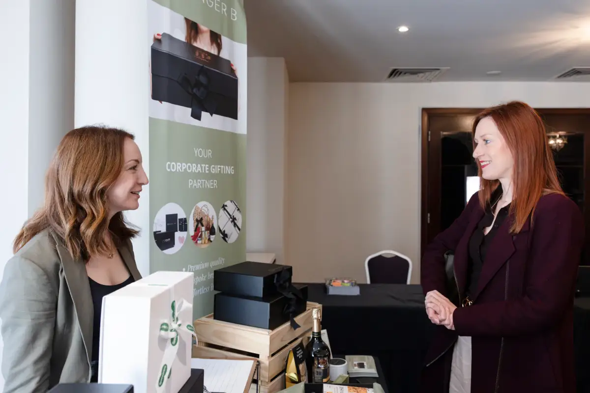 Exhibitor speaking with a delegate at a corporate gifting stand during the Intrigue MADVERSE summit in Perth