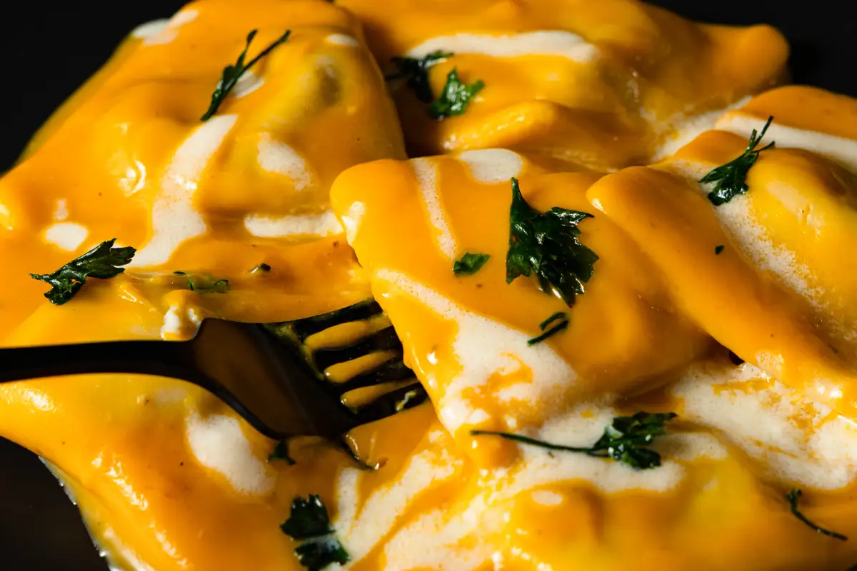 Close-up ravioli photography with rich sauce and parsley garnish at Io e Te