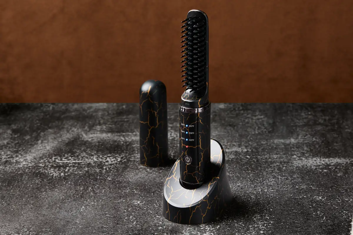 Kelly Beard Co heated beard straightener with black and gold detailing photographed on a stone surface